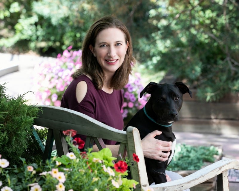 woman holding a black dog